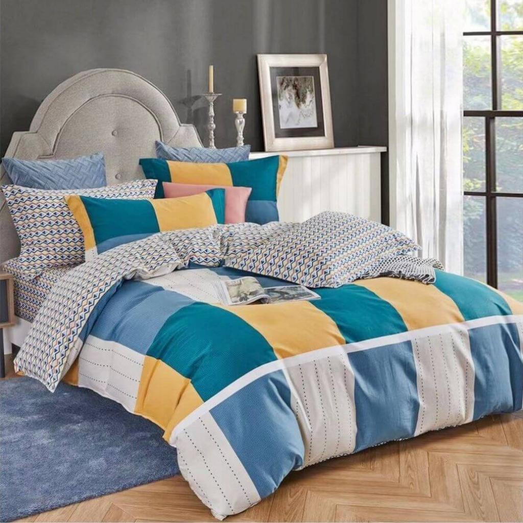 Hero image: Bộ chăn ga Amando Dormi trải trên giường — rõ kết cấu vải cotton, tông màu nhẹ, cảm giác mát mẻ.