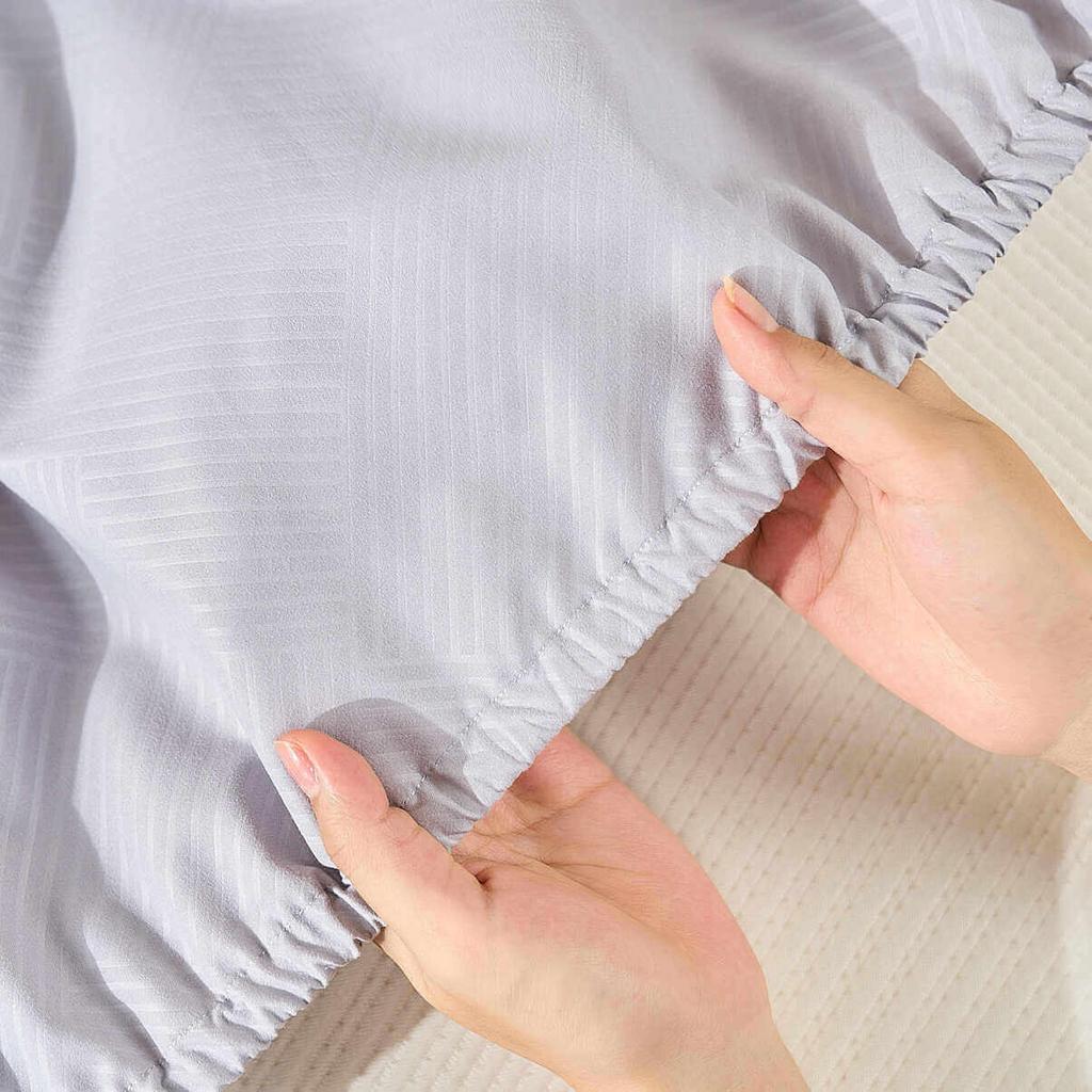 Bộ chăn ga chun Amando Rina trên giường mẫu — mềm mại, họa tiết Jacquard nổi bật.