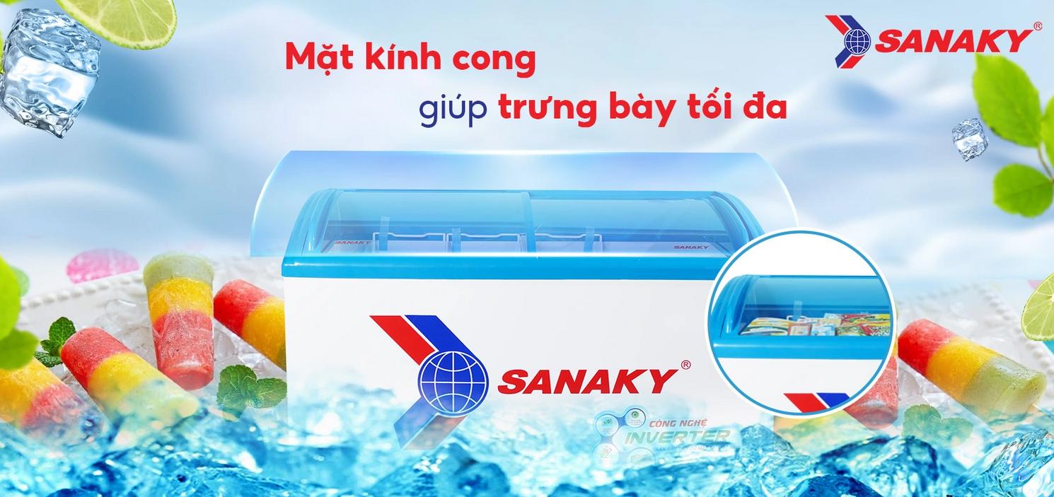 Mặt kính cong giúp trưng bày kem và thực phẩm đông lạnh bắt mắt (ảnh cửa hàng).","imagePrompt":"Wide shot of the freezer in a small shop showing curved glass and lit products inside.