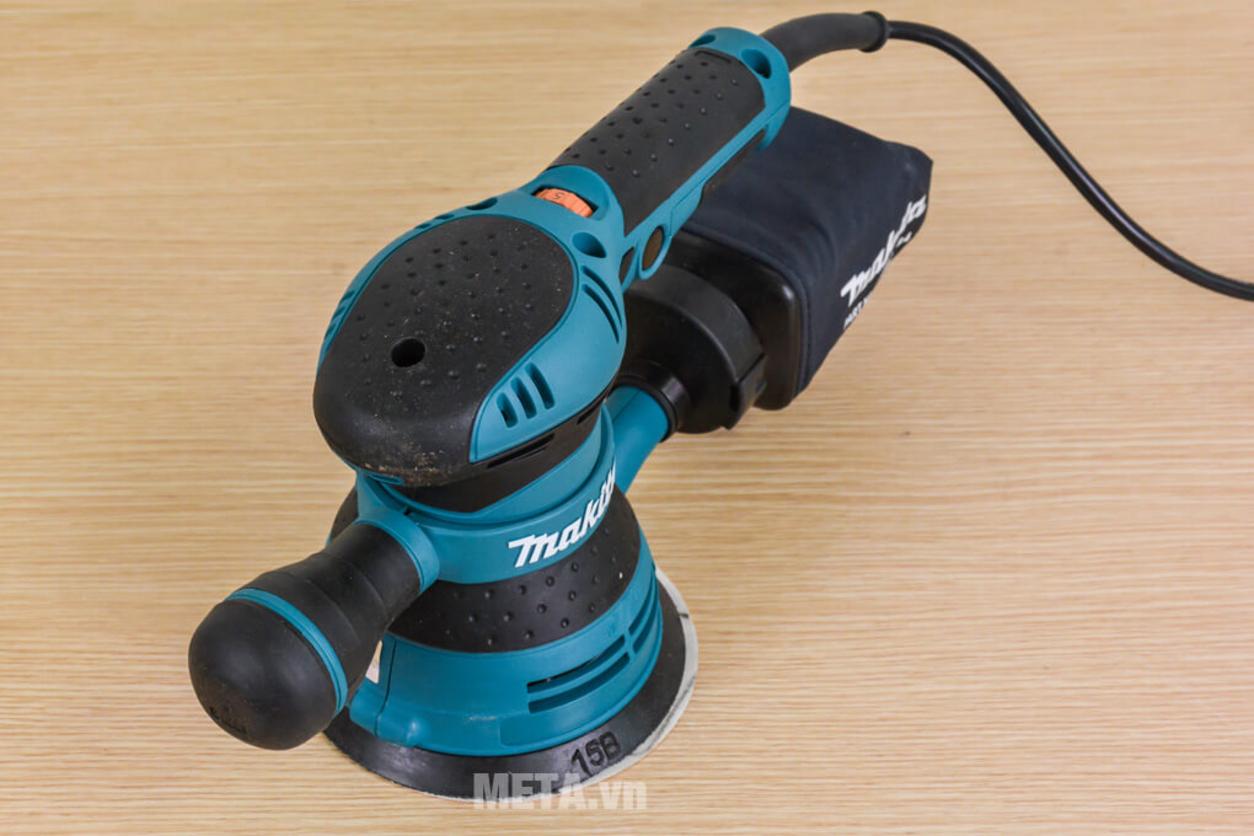 Thiết kế công thái học và hệ thống hút bụi của BO5041 — phù hợp cho công việc dài ngày.","imagePrompt":"Worker holding the sander comfortably with visible dust port and Velcro pad; clean workshop background.