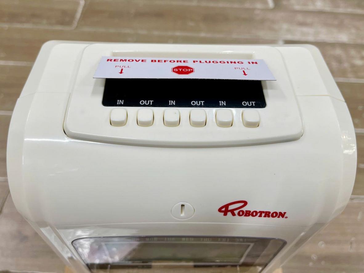 Minh hoạ in 2 màu (đỏ - đen) trên thẻ giấy của RT90D — dễ đọc, dễ đối chiếu nhân viên lúc chấm công có trễ hay không; imagePrompt: Close-up of the printed timecard showing red/black ink differentiation.