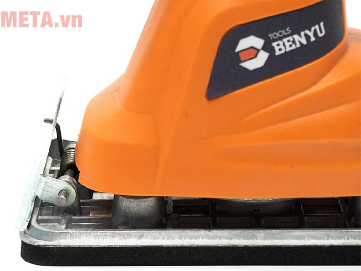Máy hoạt động trên tấm gỗ, thể hiện chuyển động rung mịn (nhìn rõ bề mặt sau khi chà).