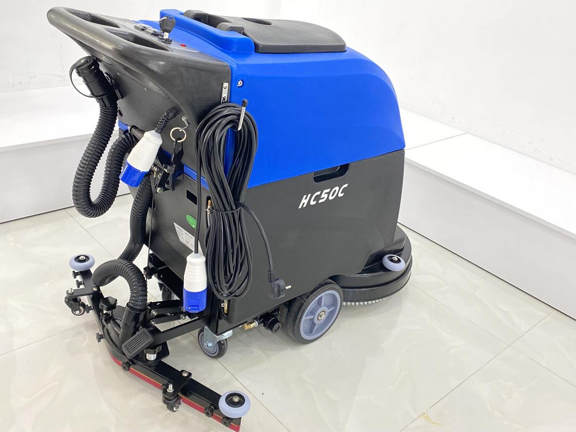 Máy chà sàn đang đi trên nền nhà kho lớn, phần đường đi sạch rõ rệt, minh họa năng suất 1750 m²/giờ.,"imagePrompt":"Wide shot of HC50C cleaning a large warehouse floor leaving a dry, clean path; emphasize cleaned area vs dirty.