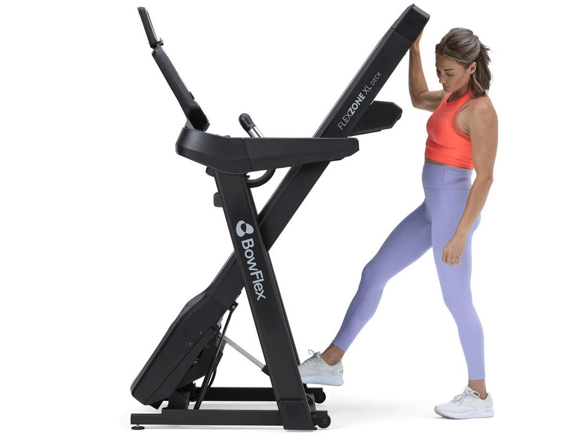 Động cơ 3.5 CHP của Bowflex T9 tạo phản hồi nhanh cho HIIT và chạy tốc độ cao; image should show motor cutaway or close-up of console controls for speed/ incline adjustment; image style: clean studio shot, human runner mid-stride, modern living room gym setting; color palette neutral with accent red/orange to highlight controls; lighting bright, shallow depth of field; composition: product left, runner right, console visible; orientation: horizontal; resolution: high; format: jpg; use natural skin tones; no logos other than Bowflex.
