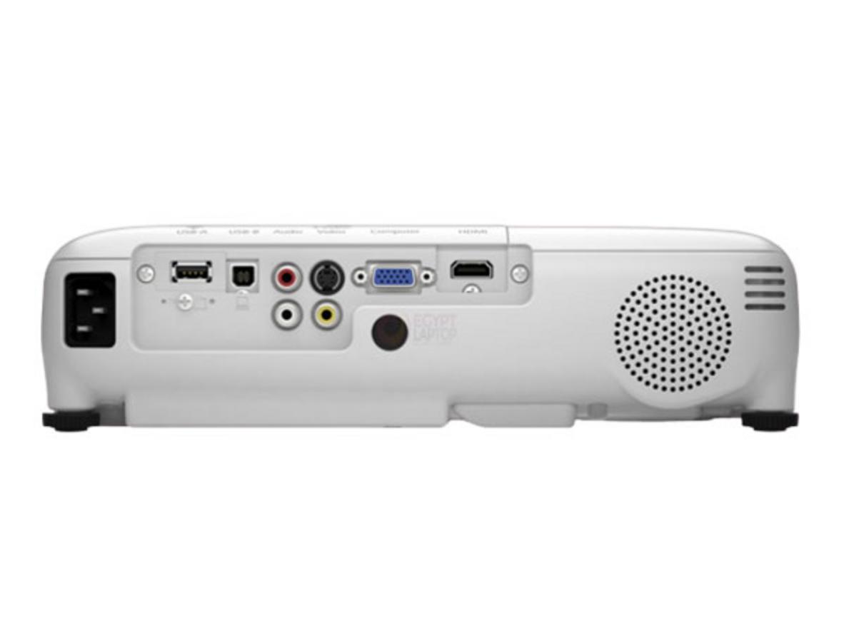 Photo showing HDMI/USB ports and a meeting room setup with presenter connecting a laptop; imagePrompt: A presenter plugging a laptop into the Epson EB-X06 via HDMI, with remote control and cables visible.